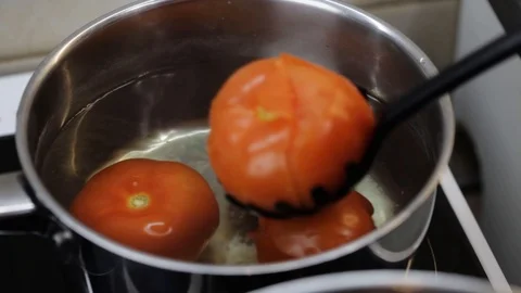 Removing tomatoes from the boiling water Stock Footage 121118820