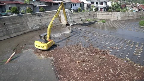 Removing trash from a river with a bulldozer Stock Footage 337976196