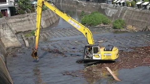 Removing trash from a river with a bulldozer Video stock 337976218
