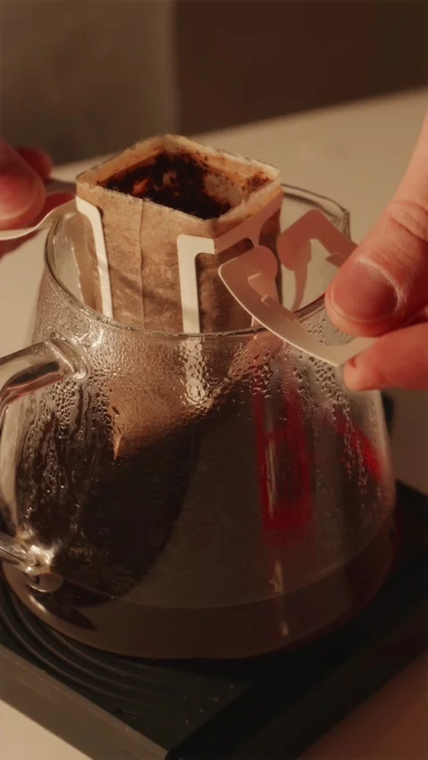 Removing used drip coffee bag from glass server vertical POV Stock Footage 332720306