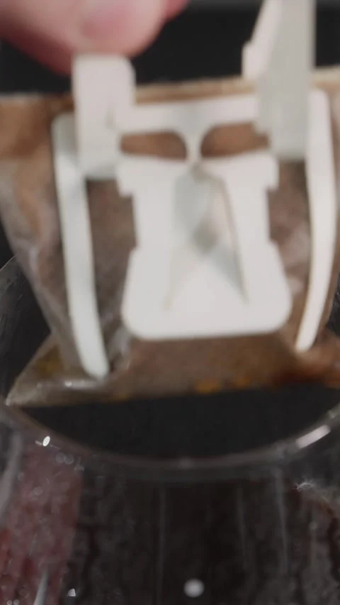 Removing used drip coffee bag from glass server vertical Stock Footage 338395200
