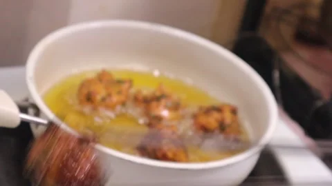 Removing Veg pakora from frying pan after frying  Stock Footage 328723922