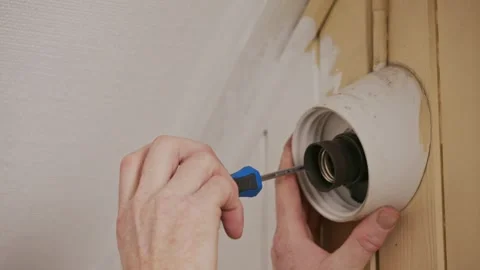 Removing wall light socket during home repair Stock Footage 325843957