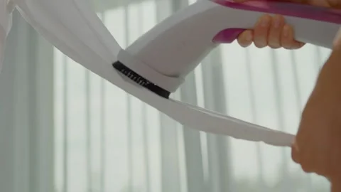 Removing wrinkles from delicate fabric using a clothing steamer at home Video stock 324648877