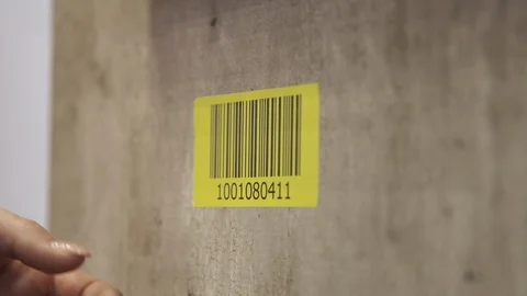 Removing a Yellow Logistics Scanner Barcode Sticker from a Concrete Wall 스톡 동영상 118547560