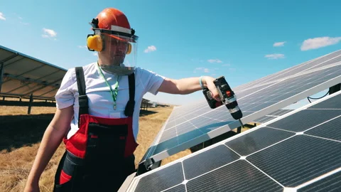 Renewable electricity concept. Solar panels are being drilled by a repairman Stock Footage 146522096