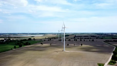 Renewable energy being generated by wind turbines on farmland creating Stock Footage 159608932