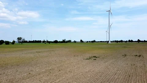 Renewable energy being generated by wind turbines on farmland creating Stock Footage 159610143