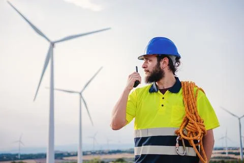 Renewable energy engineer or windmill turbine technician working and talking by Stock Photos