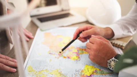 Renewable energy engineer pointing at world map and show colleagues planned.. Stock Footage 346173180