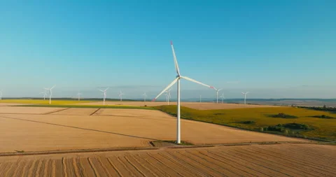 Renewable energy farm multiple wind turbines spread across endless golden fields Stock Footage 301876133