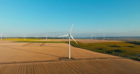 Renewable energy farm multiple wind turbines spread across endless golden fields Stock Footage 301877263