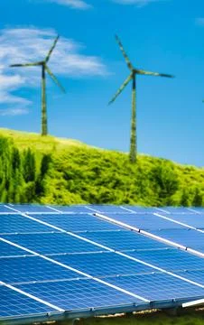Renewable energy sources including wind turbines on grassy hill and solar p.. Stock Photos