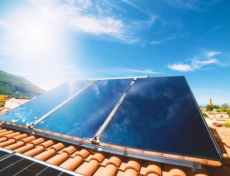 Renewable energy system with solar panel for hot water Foto stock