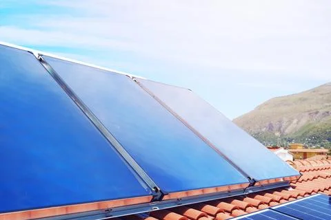 Renewable energy system with solar panel for electricity and hot water Stock Photos