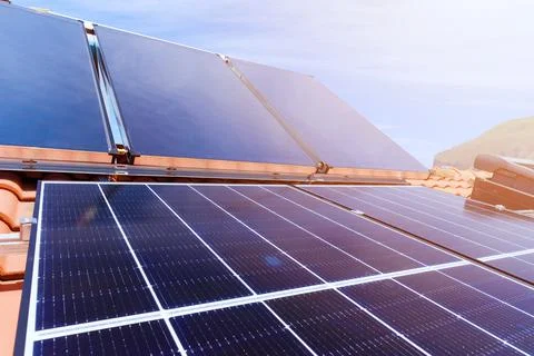 Renewable energy system with solar panel for electricity and hot water Stock Photos