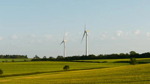 Renewable power generating from modern wind turbines across farmland landscape Stockbeeldmateriaal 339342876