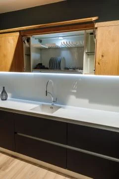 Renovated kitchen interior with elegant tableware in cupboard Stock Photos