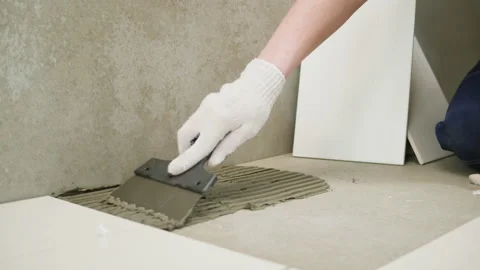 Renovation and construction. Builder laying ceramic tiles using cement close-up Stock Footage 195122916