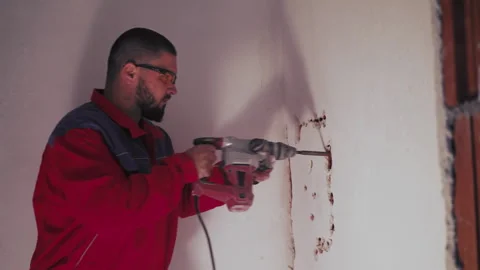 Renovation and redevelopment. Portrait of worker with a hammer drill Stock Footage 241071150