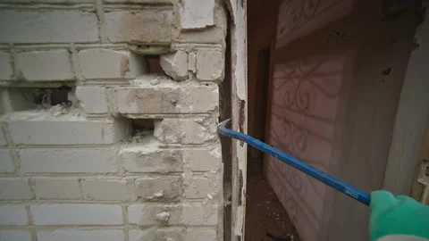 Renovation Process Carefully Opening a Wall for Inspection and Assessment of the Stock Footage 314570654