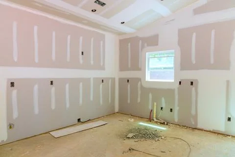 Renovation process in an empty room with drywall, construction debris Stock Photos
