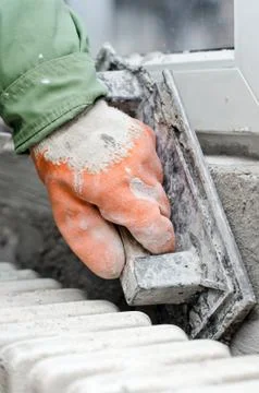 Renovation - workers hand captured while finishing works around replaced window Stock Photos