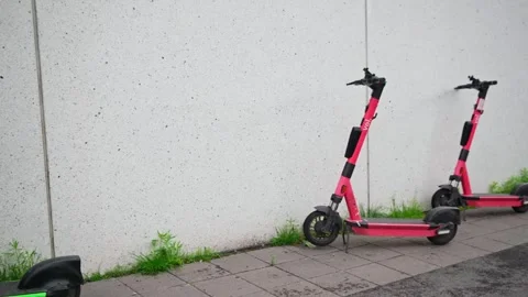 Rental e-scooters parked next to a building wall in Jyvaskyla, Finland Stock Footage 313219037
