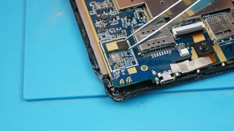 Repair chips using a soldering iron and tweezers.On the blue rubber Mat. Stock-Footage 133240189