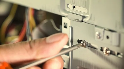 Repair of a computer: technician with a screwdriver is screwing the pc cabinet Stock-Footage 77770552