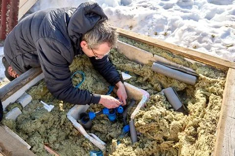 Repair of distribution piping inside artesian well pit. Stock Photos