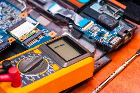 Repair an electronic device using a multimeter by measuring the voltage Stock Photos