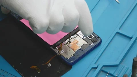 Repair of electronics in the service.Opens the smartphone with a screwdriver. Stock-Footage 145417493