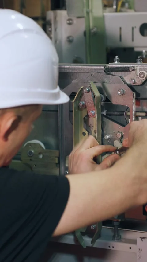 A repair engineer is fixing the elevator, the doors are open. A repairman uses a Stock Footage 300877731