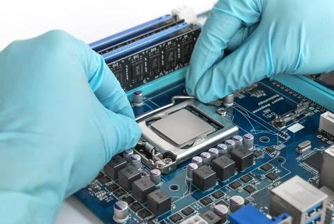 A repair engineer installs a processor chip into a circuit board socket 库存照片
