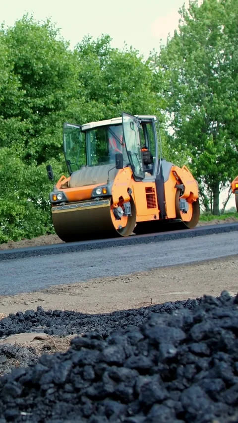 Repair of a highway, roller compactor machine and asphalt finisher laying a new Stock Footage 317845558