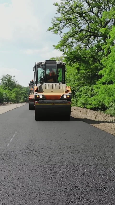 Repair of a highway, roller compactor machine and asphalt finisher laying a new Stock Footage 318235848