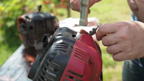 Repair of a lawn mower. a man changes a candle in a mower. replacement of the Stock Footage 170822610