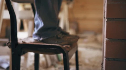 A repair man with a bucket of solution is descending of a chair after finishing Stock Footage 90091367
