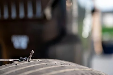 Repair plug being inserted to patch a nail tire puncture Stock Photos