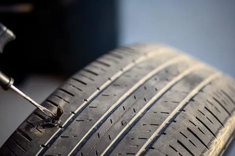 Repair plug being inserted to patch a nail tire puncture Stock Photos