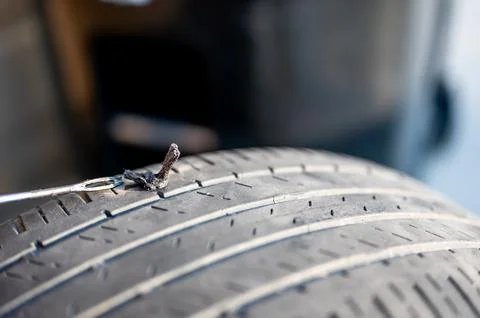 Repair plug being inserted to patch a nail tire puncture Stock Photos