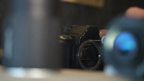 Repair screw tightened on unrecognizable second hand camera, close shot Stock Footage 241484802
