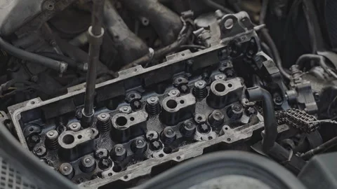 In a repair shop, mechanic is working on the engine head of car Stock Footage 337455757