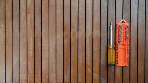 Repair tools screwdriver with bits in a case on a wooden background Stock Photos