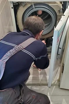 Repair of washing machines. The master disassembles the washing machine to fix Stock Photos