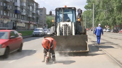 Repair work on the road. A worker saws asphalt. Stock Footage 131959632