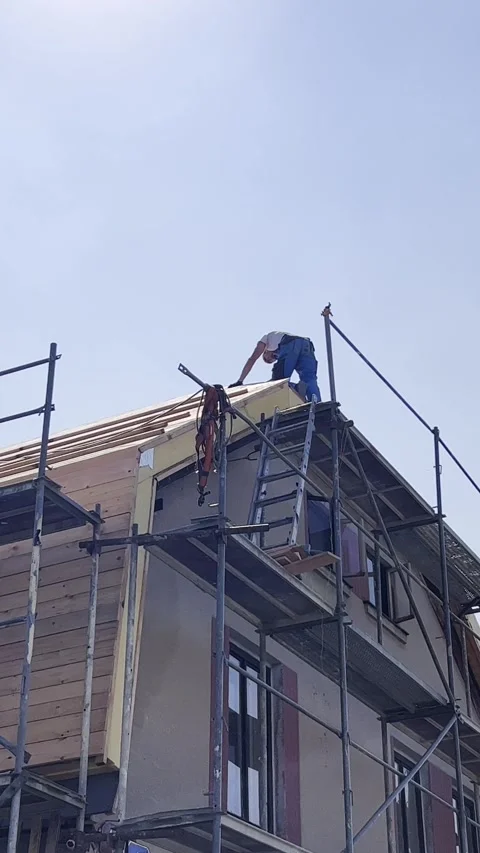Repair work on the roofing of the house. The builder works on the top of the Stock Footage 250386648