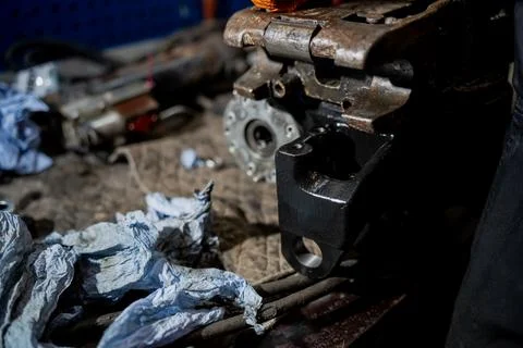 Repaired hydraulic machinery component on workshop table with tools Stock Photos