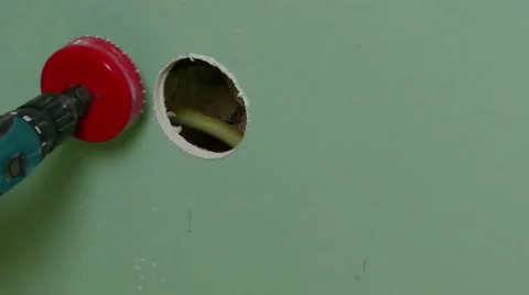 Repairer Make Drilling a Round Hole in a Drywall Stock Footage 43617595